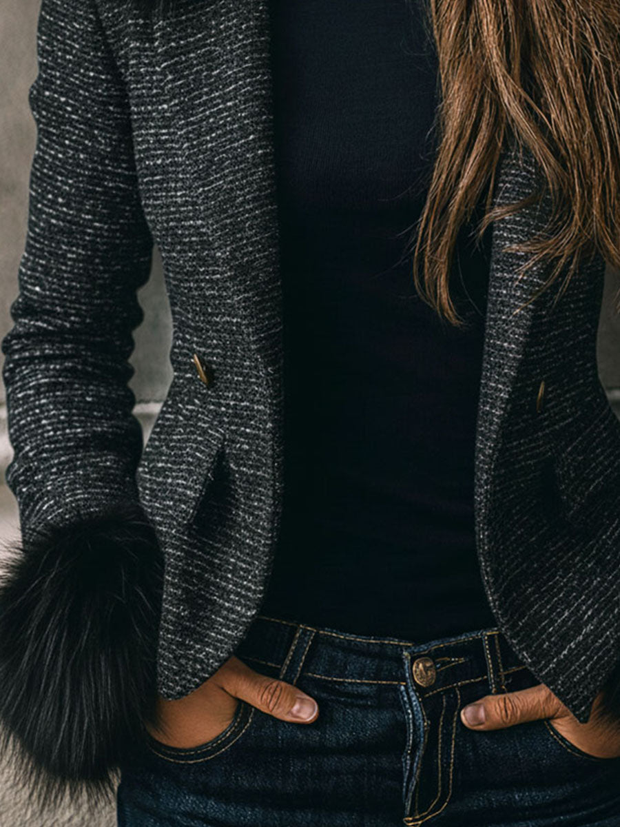 A Black Puffer Jacket With Gold Chain Trim, Zippers, And Buttons On The Sleeves